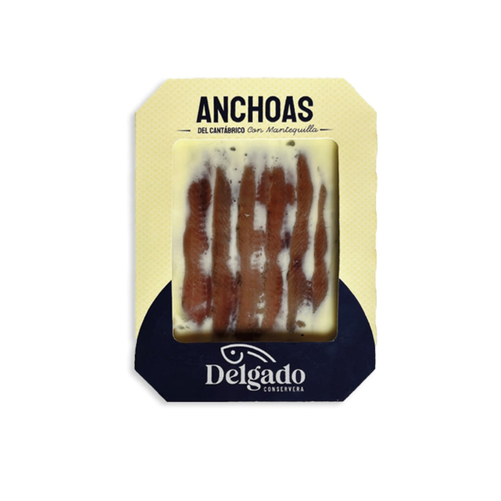 Packaged Cantabrian anchovies preserved in butter, branded by Delgado, with a white and blue label.