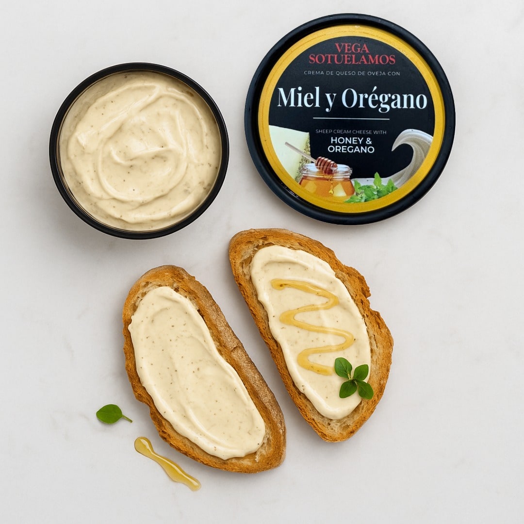 Honey and oregano cream spread on bread with a container of the product.