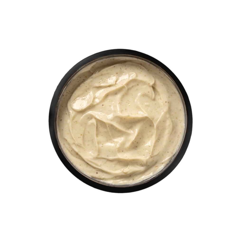 Black bowl filled with creamy beige substance on a white background