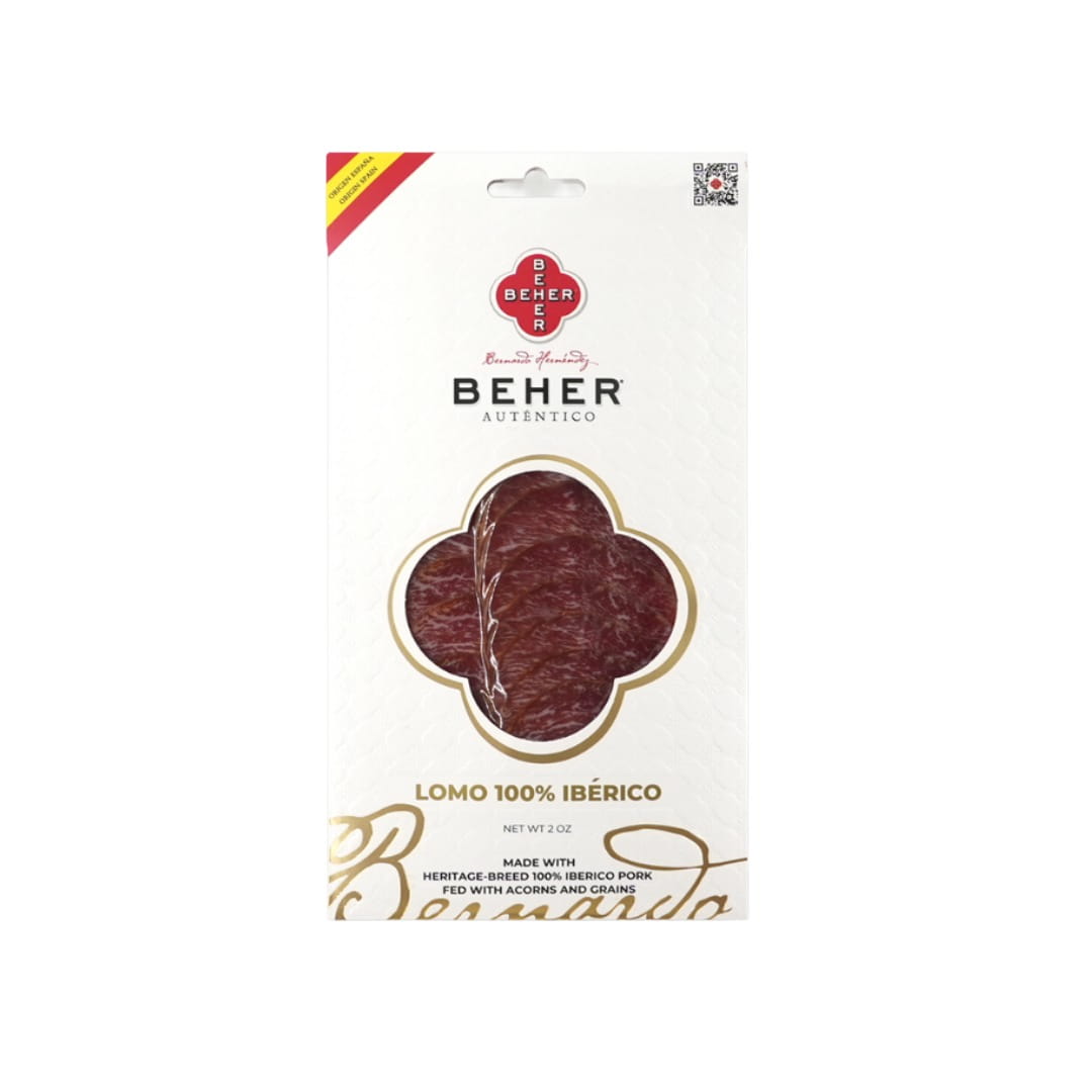 Beher Lomo 100% Ibérico meat in its original white packaging with a gold and red design, featuring a four-petal shape cutout showing the marbled red meat inside.