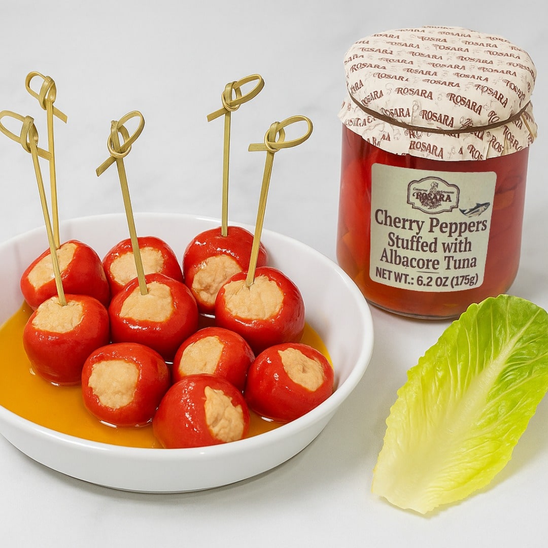 Stuffed cherry peppers with a jar of Rosana Cherry Peppers Stuffed with Albacore Tuna on a white background.