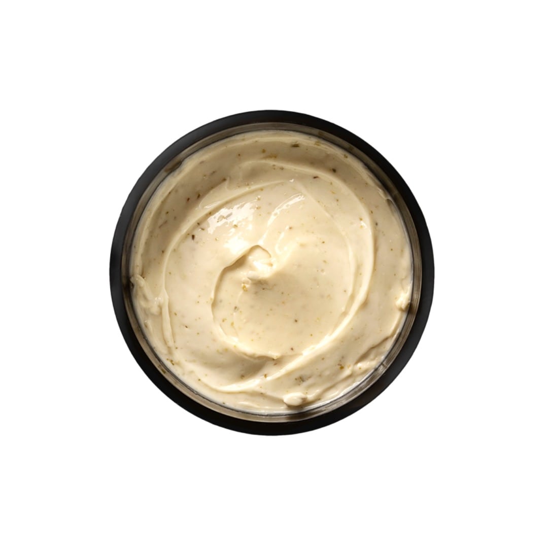 Black container of creamy beige substance on a white background