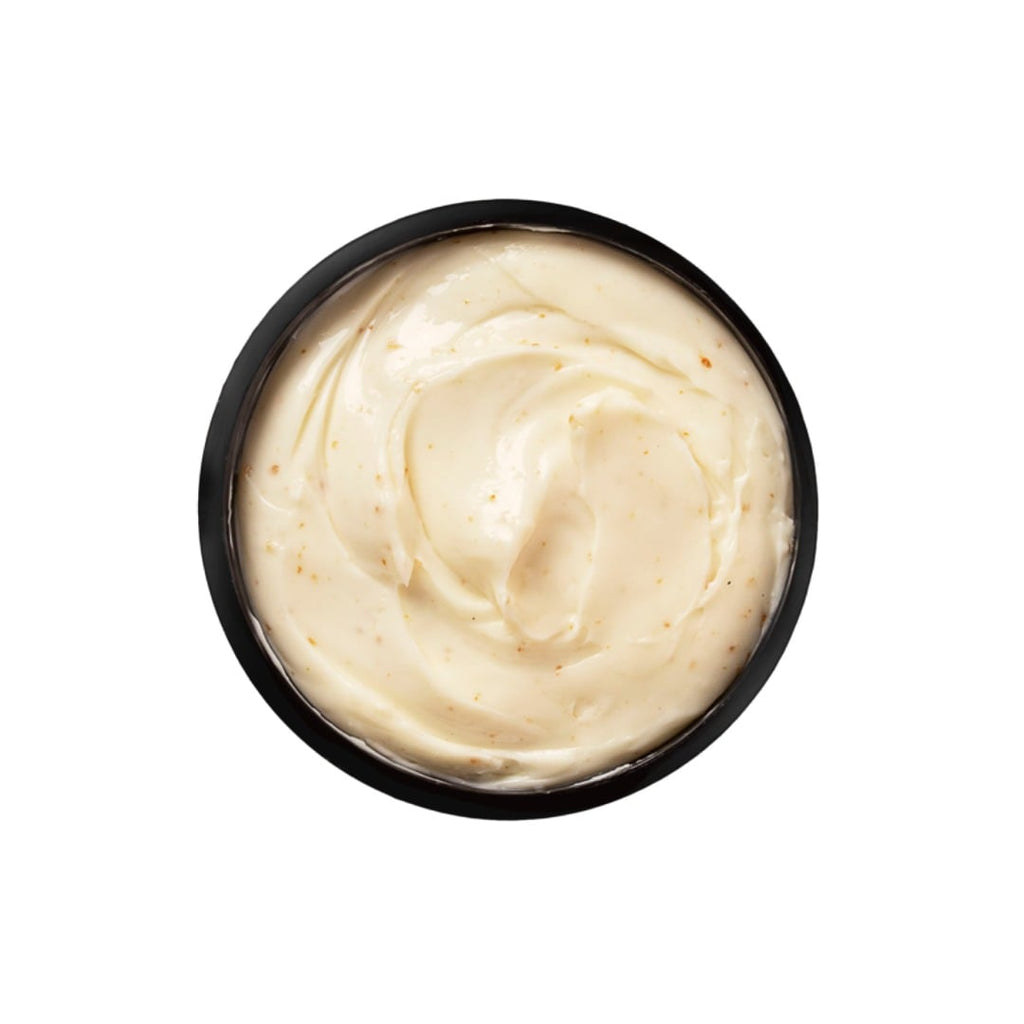 Black container filled with creamy white substance on a white background